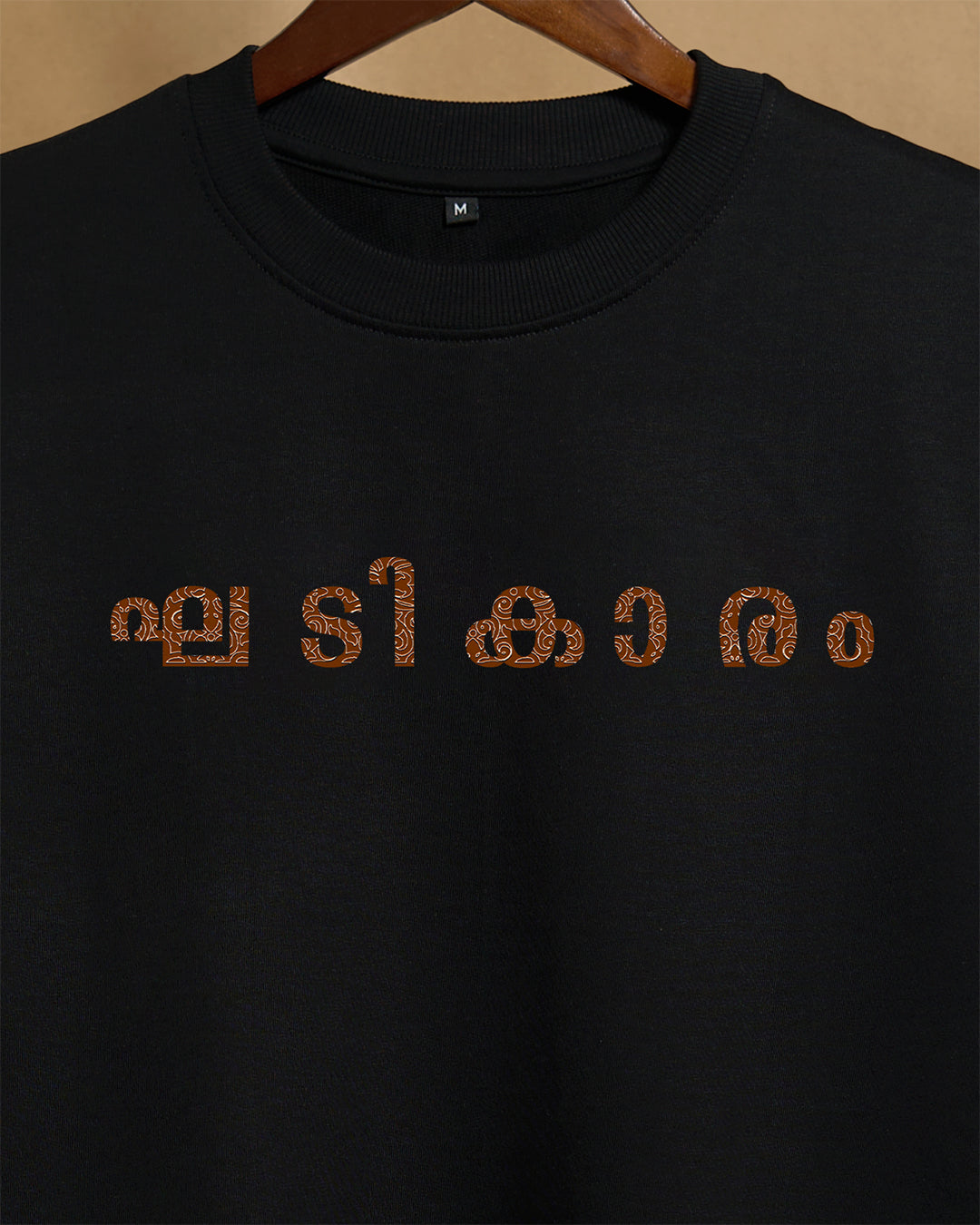 Close-up of black Gadikaram unisex oversized T-shirt by Printrove, showing front detail and 240GSM fabric texture.